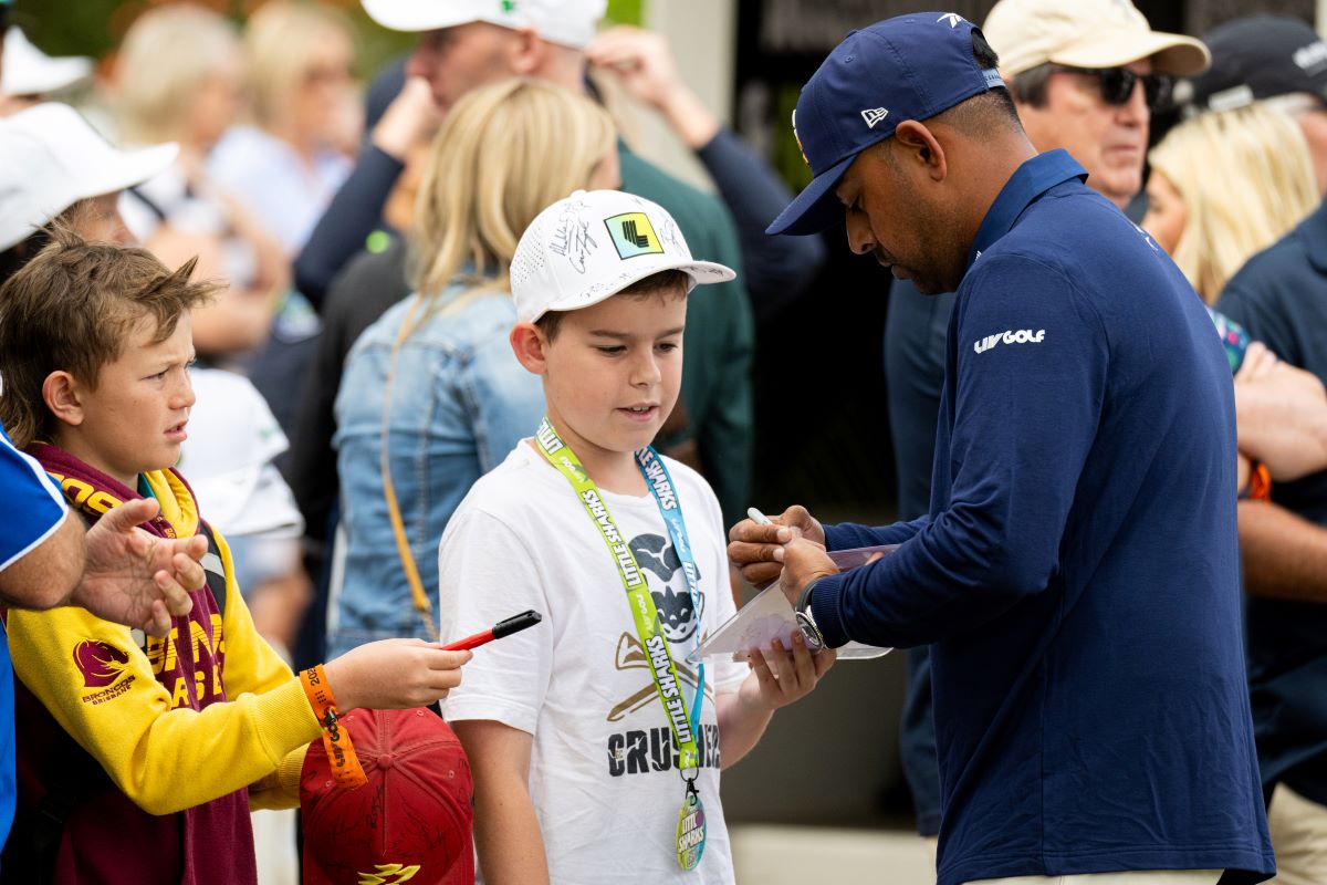 Young junior golfer practicing under coach supervision